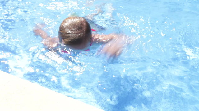 View Of Girl In Swimming Pool Wearing Goggles And Waving