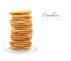 Pile of assorted crackers on a small glass plate,  isolated on w
