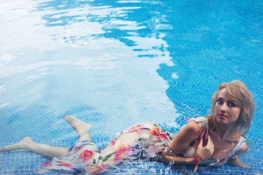 Young blonde woman in the swimming pool, fashion portrait.
