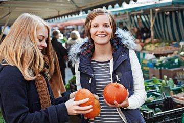 Fototapeta premium two young women looking at Hokkaido pumpkins