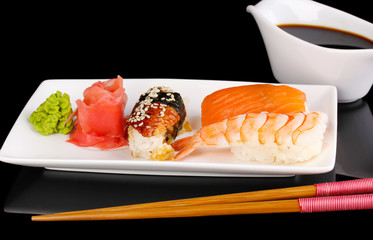 delicious sushi served on plate isolated on black