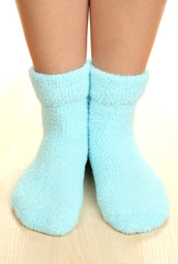 Legs female in blue socks on laminate floor