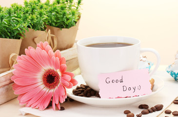 cup of coffee and gerbera beans, cinnamon sticks on wooden