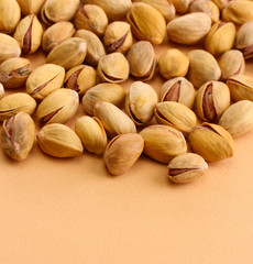 tasty pistachio nuts, on beige background
