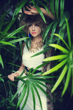 Lady in a fur hat in the jungle, fashion portrait.