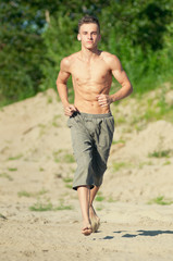 Young man running on beach