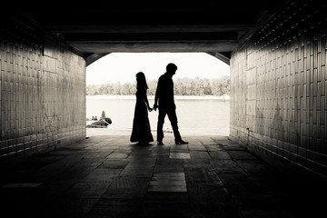 Silhouette of a couple on bright background in a tunnel