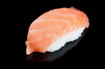 Sushi with salmon on a black plate, horizontal shot