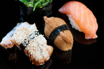 Black plate with variety of sushi, studio shot