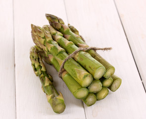 Useful asparagus close-up on wooden table on white background