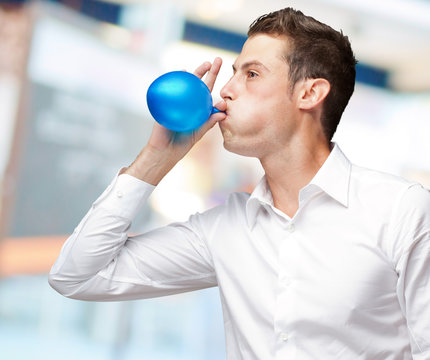 Portrait Of Young Man Blowing A Balloon