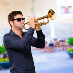 A Young Man Blowing A Trumpet