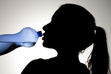 girl drinking water from blue bottle