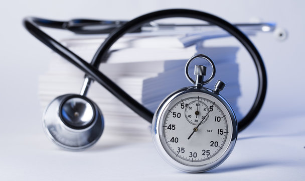 Pile of paper cards, stethoscope and stopwatch