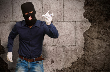 Man wearing robber mask and holding airplane miniature