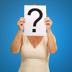 mature woman holding question mark sign