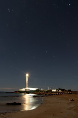 Fototapeta na wymiar Lighthouse with a beam of light