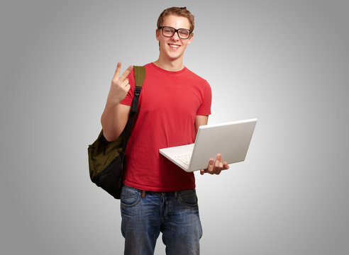 man holding laptop and backpack