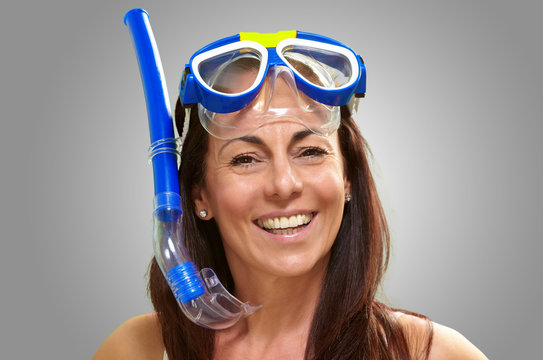 portrait of a happy middle aged woman wearing snorkel and goggle