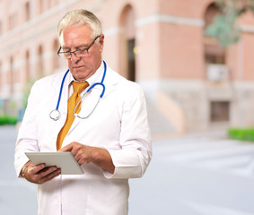 Portrait Of A Male Doctor Holding A Tab