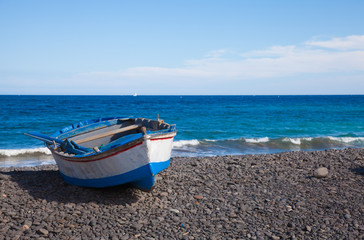 Fuerteventura, old  boat on black volcanic stone beach in Pozo N