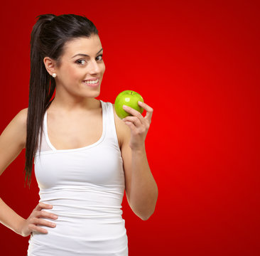 Young woman holding and eating an apple