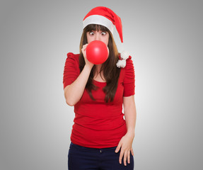 christmas woman blowing a balloon with her eyes crossed