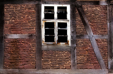 Old broken window in the wall of old house