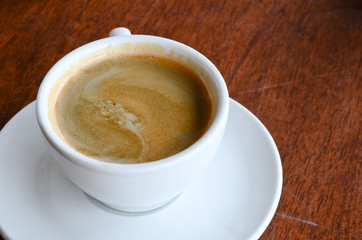 A cup of coffee on wooden background