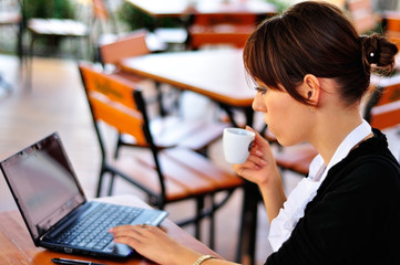 Female with a cup of coffee using laptop