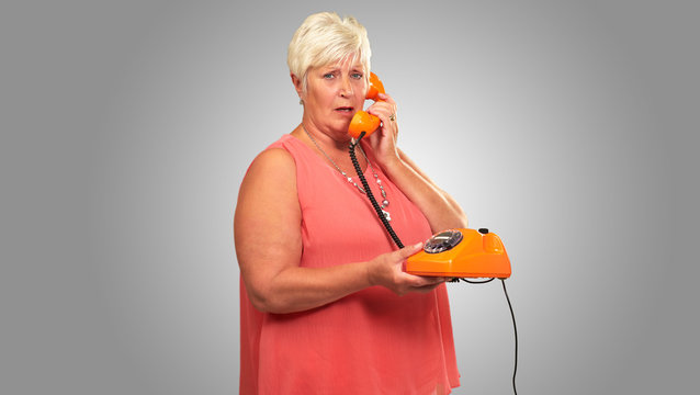 Portrait Of A Senior Woman Holding A Retro Phone