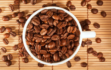 White cup with coffee beans on the table