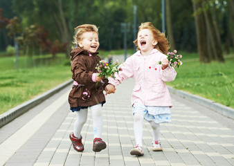 two little laughing kids girls outdoors