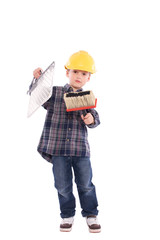 Junge steht mit Malerbürste und Bauhelm