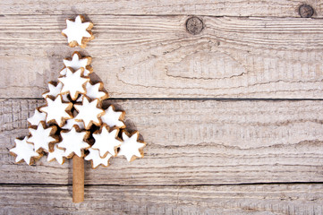 Weihnachtsbaum aus Zimtsternen auf Holz - obrazy, fototapety, plakaty