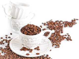 Coffee beans in a cup on white background