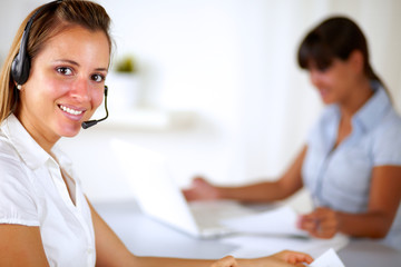 Young friendly receptionist wearing headphone