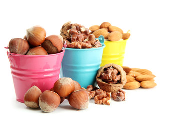 Fototapeta na wymiar assortment of tasty nuts in pails, isolated on white
