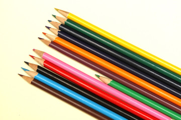 Assortment of coloured pencils with shadow on white background