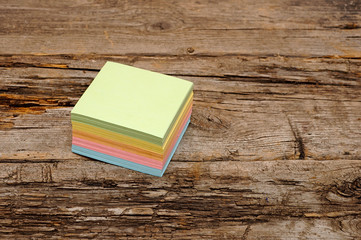 Vibrant block of colorful post it notes on wooden background