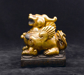 An antique golden lion made of stone