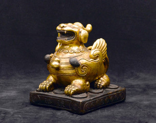 An antique golden lion made of stone