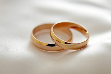 Two wedding rings with white flower in the background, wedding p