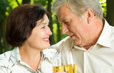 Senior couple celebrating with champagne, outdoors