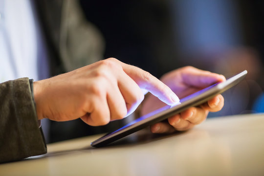 finger touching tablet screen