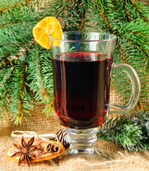 Glühwein mit Orange und Zimt vor Tannenzweigen