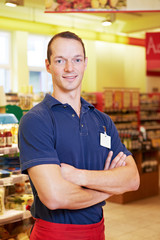 Supermarkt-Mitarbeiter mit verschränkten Armen