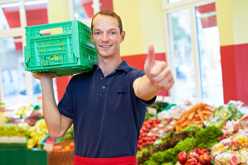 Mitarbeiter im Supermarkt hält Daumen hoch