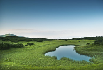 Morning near small mountainous pond