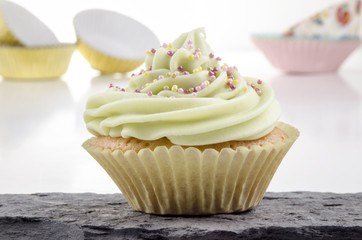 Cupcake mit Limetten Buttercreme und bunten Zuckerperlen
